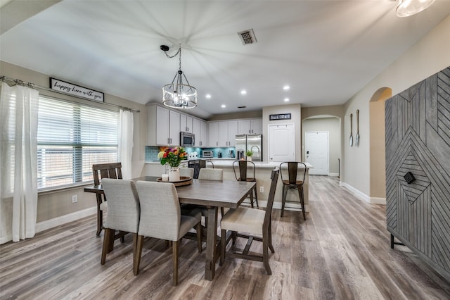 1289 Lasso Dr, Little Elm, TX 75068 - dining room featuring arched walkways, light wood finished floors, a chandelier, and recessed lighting