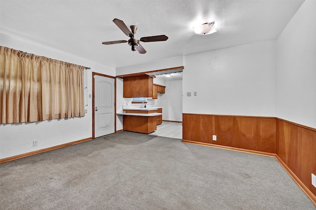 1402 Hillcrrest Dr, Sherman, TX 75092 - unfurnished living room with a ceiling fan, light colored carpet, wainscoting, and wood walls