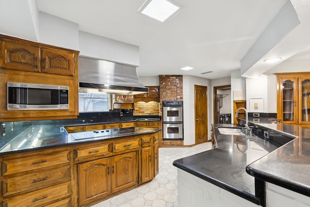 1605 Canyon Oaks Dr, Irving, TX 75061 - kitchen featuring stainless steel appliances, light floors, dark countertops, and brown cabinets