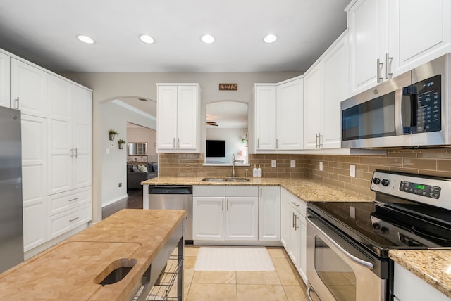 8571 Hidden Spring Dr, Frisco, TX 75034 - kitchen with appliances with stainless steel finishes, arched walkways, tasteful backsplash, white cabinets, and recessed lighting