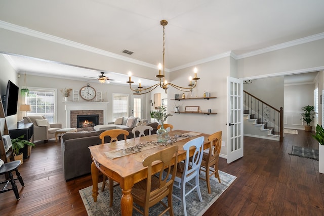 8571 Hidden Spring Dr, Frisco, TX 75034 - dining area featuring a lit fireplace, crown molding, dark wood-type flooring, stairs, and a ceiling fan