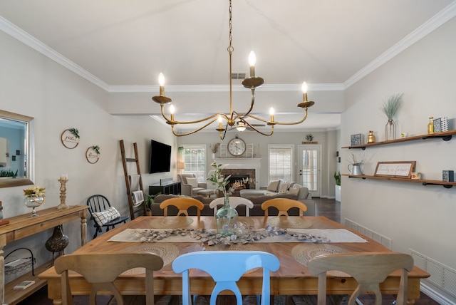 8571 Hidden Spring Dr, Frisco, TX 75034 - dining room with crown molding, a chandelier, and a fireplace
