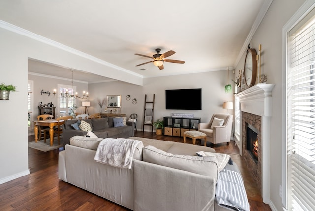 8571 Hidden Spring Dr, Frisco, TX 75034 - living area featuring a glass covered fireplace, a ceiling fan, a chandelier, dark wood-style floors, and ornamental molding