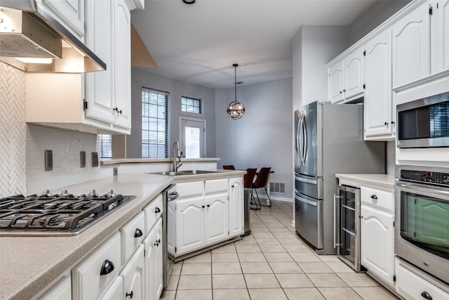8813 Greenwood Trl, Rowlett, TX 75088 - kitchen with stainless steel appliances, beverage cooler, exhaust hood, white cabinets, and backsplash