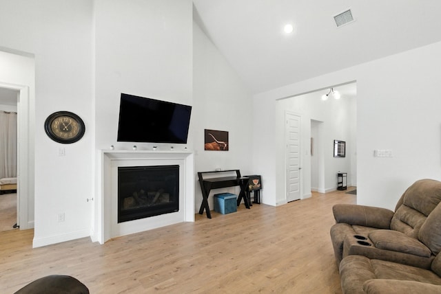 303 Highland Ct, Aledo, TX 76008 - living room with high vaulted ceiling, light wood-style floors, and a glass covered fireplace