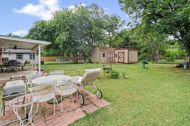 1104 Center St, Cleburne, TX 76033 - fenced backyard with outdoor dining area, a storage unit, a patio area, ceiling fan, and view of wooded area
