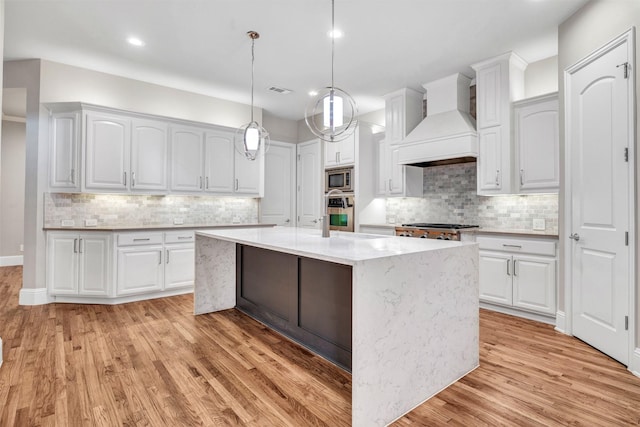 11334 Graceland Ln, Frisco, TX 75033 - kitchen featuring custom exhaust hood, stainless steel appliances, backsplash, light wood-style floors, and recessed lighting