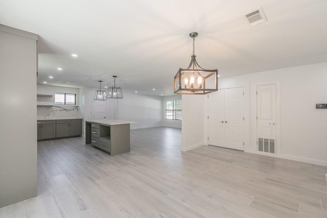 13516 Spring Grove Ave, Dallas, TX 75240 - kitchen with a chandelier, gray cabinetry, open floor plan, a kitchen island, and recessed lighting