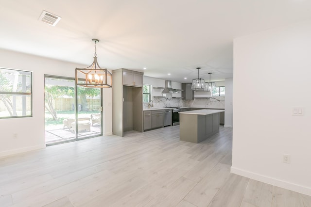 13516 Spring Grove Ave, Dallas, TX 75240 - kitchen featuring gray cabinets, wall chimney range hood, light countertops, a chandelier, and tasteful backsplash