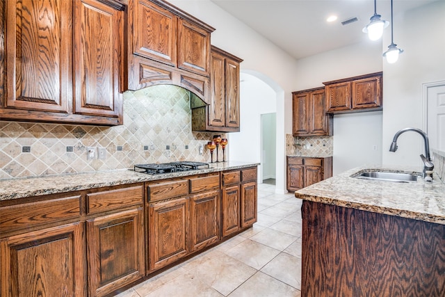 7611 Forest Ridge Trl, Sachse, TX 75048 - kitchen featuring gas cooktop, backsplash, light stone countertops, and pendant lighting