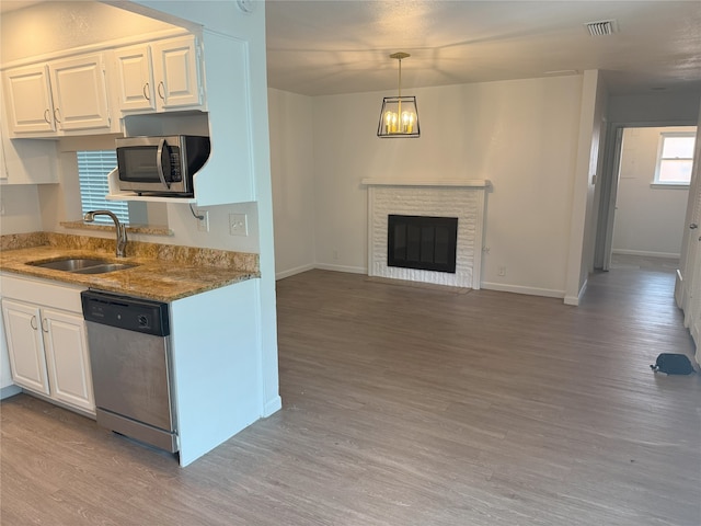 4005 Tacoma St, Irving, TX 75062 - kitchen featuring stainless steel appliances, light stone counters, light wood-style flooring, and white cabinets