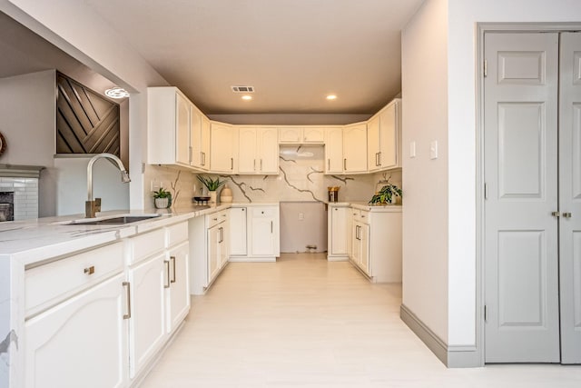 947 Aspen Dr, Desoto, TX 75115 - kitchen with backsplash, light stone counters, recessed lighting, light wood-type flooring, and a fireplace