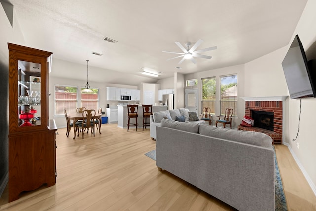 90 Elmwood Trl, Waxahachie, TX 75165 - living room featuring ceiling fan, light wood-type flooring, a fireplace, and vaulted ceiling