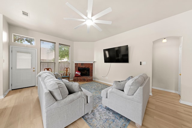 90 Elmwood Trl, Waxahachie, TX 75165 - living area featuring ceiling fan, light wood finished floors, arched walkways, and a fireplace