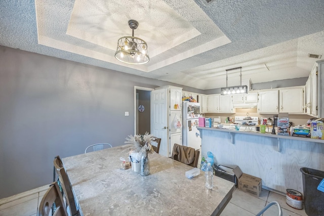 3612 Hummingbird Ave, Mcallen, TX 78504 - dining area featuring a textured ceiling, a raised ceiling, a chandelier, and light tile patterned floors