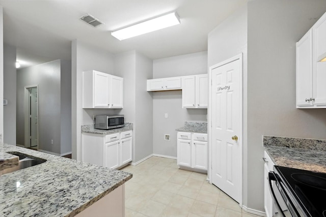 3136 Deleon Dr, Plano, TX 75025 - kitchen featuring stainless steel microwave, light stone countertops, and white cabinetry
