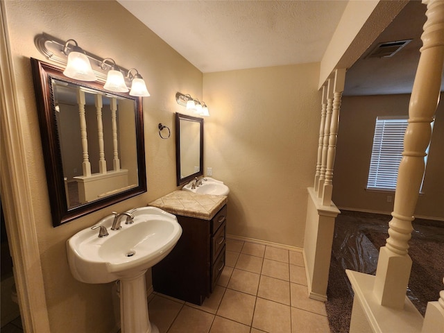 1408 Bandera Dr, Arlington, TX 76018 - bathroom with tile patterned flooring, two sinks, and a textured ceiling