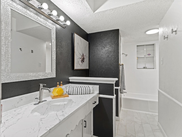2012 Westlake Dr, Plano, TX 75075 - bathroom featuring vanity, shower / tub combination, a textured wall, marble look tile flooring, and a textured ceiling
