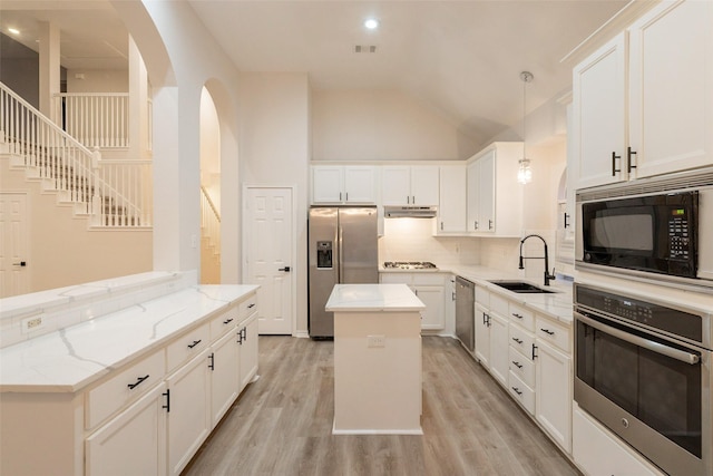 5920 Colby Dr, Plano, TX 75094 - kitchen with appliances with stainless steel finishes, a peninsula, arched walkways, a center island, and tasteful backsplash