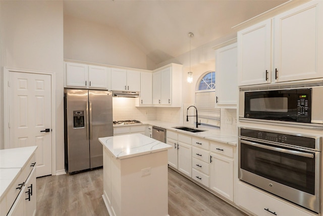 5920 Colby Dr, Plano, TX 75094 - kitchen featuring appliances with stainless steel finishes, under cabinet range hood, lofted ceiling, decorative backsplash, and light wood-style floors