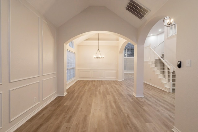 5920 Colby Dr, Plano, TX 75094 - entrance foyer featuring a chandelier, a decorative wall, stairs, light wood-style flooring, and wainscoting