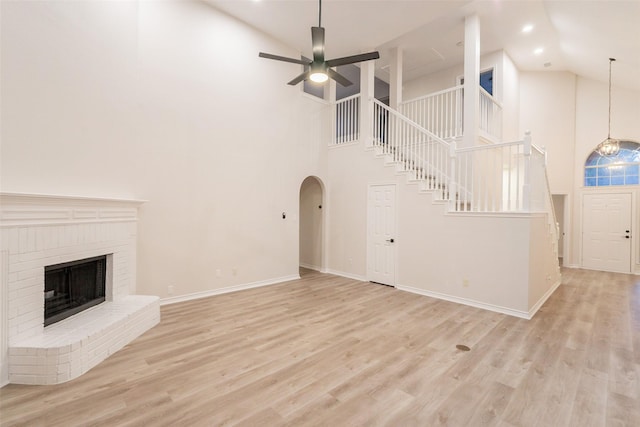 5920 Colby Dr, Plano, TX 75094 - unfurnished living room with high vaulted ceiling, ceiling fan, light wood-style flooring, stairs, and arched walkways