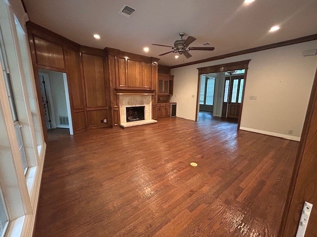 6 Oak Forrest Cir, Denton, TX 76210 - unfurnished living room featuring ceiling fan, a fireplace with raised hearth, dark wood finished floors, crown molding, and recessed lighting