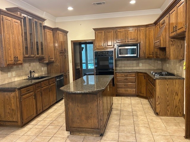 6 Oak Forrest Cir, Denton, TX 76210 - kitchen with appliances with stainless steel finishes, decorative backsplash, light tile patterned floors, a kitchen island, and crown molding