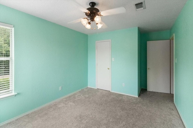 2826 Garden Oaks Pl, Grand Prairie, TX 75052 - unfurnished bedroom featuring multiple windows, carpet floors, a ceiling fan, and a textured ceiling