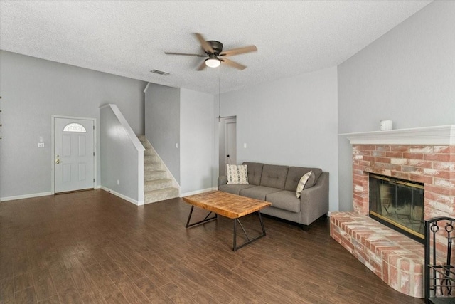 2826 Garden Oaks Pl, Grand Prairie, TX 75052 - living room with ceiling fan, stairway, a brick fireplace, wood finished floors, and a textured ceiling
