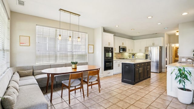 2945 Horseshoe Trl, Frisco, TX 75033 - kitchen with black appliances, light countertops, open floor plan, light tile patterned flooring, and decorative backsplash