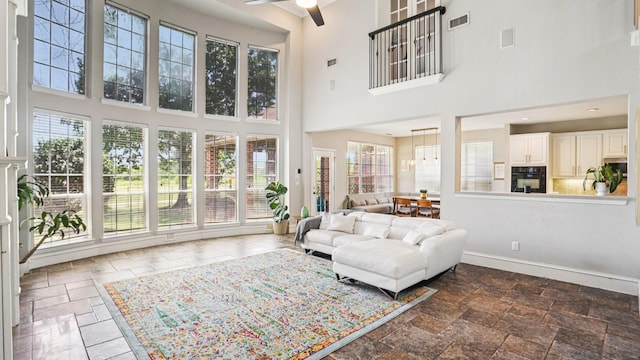 2945 Horseshoe Trl, Frisco, TX 75033 - living room featuring a high ceiling, a ceiling fan, and stone tile flooring