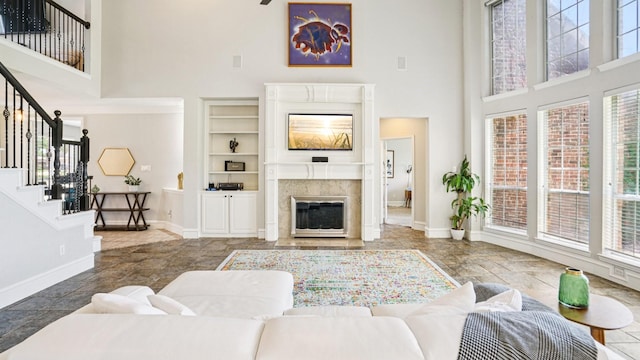 2945 Horseshoe Trl, Frisco, TX 75033 - living area featuring a high ceiling, stairway, a premium fireplace, stone finish flooring, and built in features