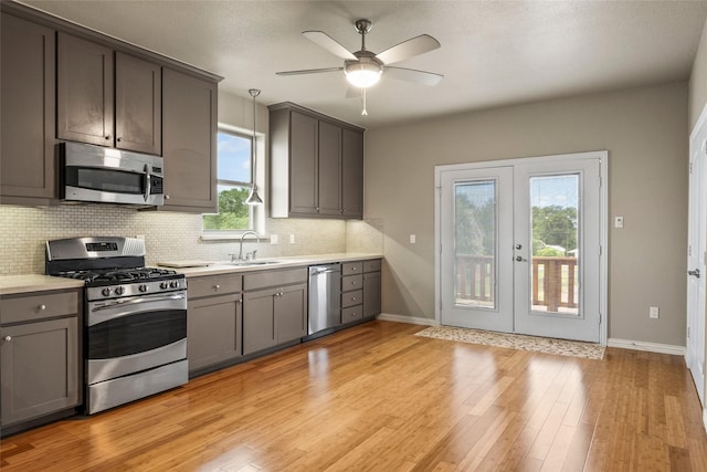 2910 Eagles Nest Ct, Midlothian, TX 76065 - kitchen with appliances with stainless steel finishes, french doors, tasteful backsplash, light countertops, and ceiling fan