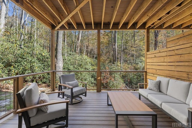 wooden terrace with an outdoor living space