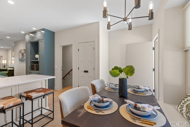 dining space with a notable chandelier and light hardwood / wood-style flooring