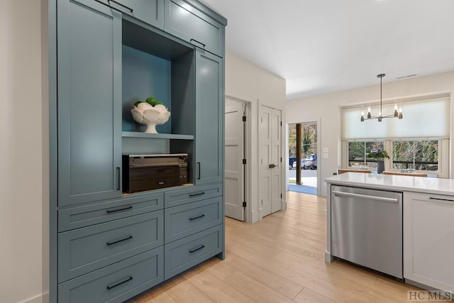 kitchen featuring light wood-type flooring, stainless steel dishwasher, a chandelier, and decorative light fixtures