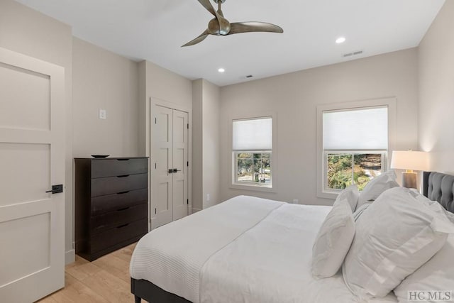 bedroom with light hardwood / wood-style floors and ceiling fan