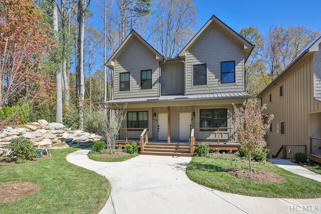 view of front of home with covered porch and a front lawn