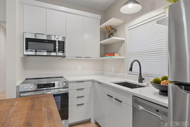 kitchen featuring appliances with stainless steel finishes, sink, and white cabinetry