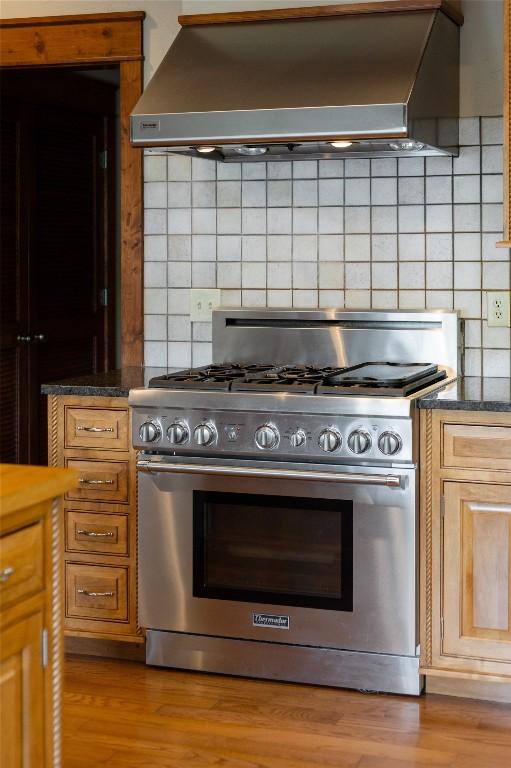 119 Old Still Rd, Sapphire, NC 28774 - kitchen featuring high end range, wall chimney exhaust hood, decorative backsplash, and wood finished floors