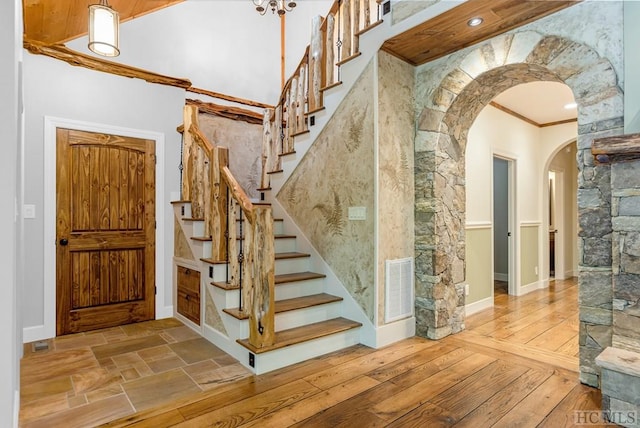 stairs with crown molding and hardwood / wood-style flooring