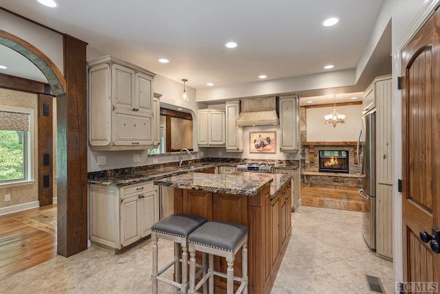 kitchen with pendant lighting, stainless steel appliances, a center island, and sink