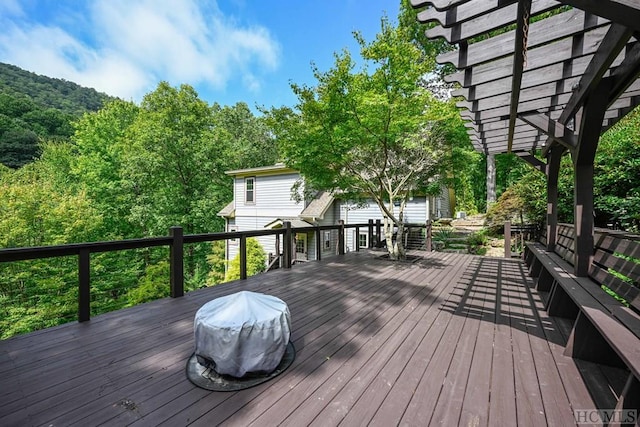 wooden terrace featuring area for grilling and a pergola