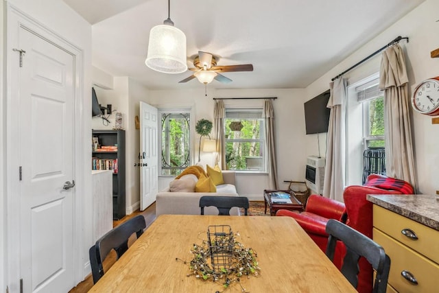 dining room with healthy amount of natural light, a ceiling fan, and baseboards