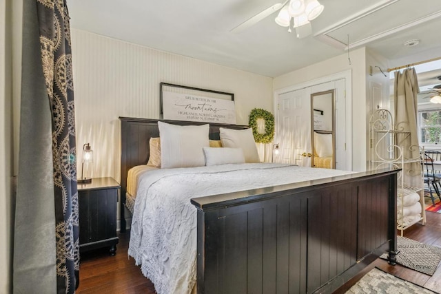 bedroom with attic access, dark wood-style flooring, and a ceiling fan