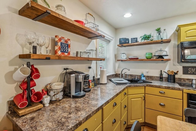 kitchen featuring open shelves, black appliances, a sink, and dark countertops