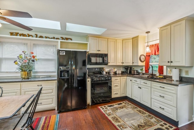 kitchen featuring black appliances, a sink, dark countertops, ceiling fan, and dark wood-style flooring