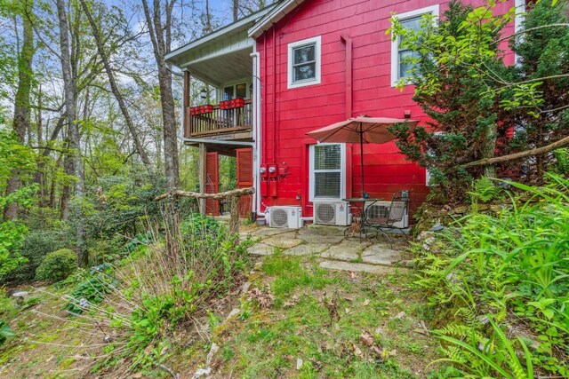 rear view of property with a cooling unit, a patio, and a balcony
