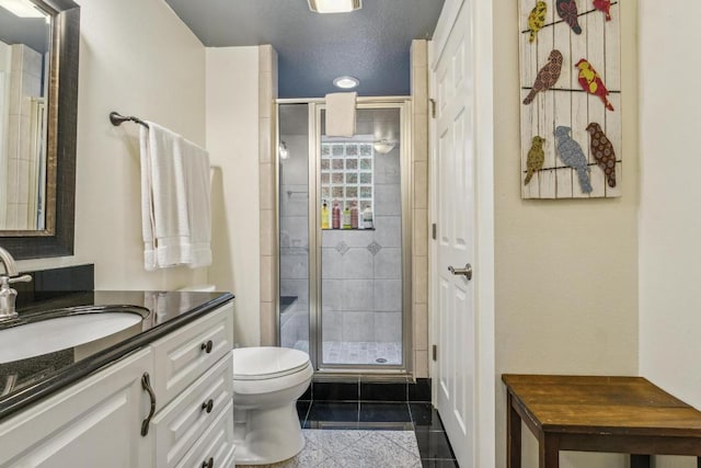 bathroom featuring toilet, a shower stall, and vanity